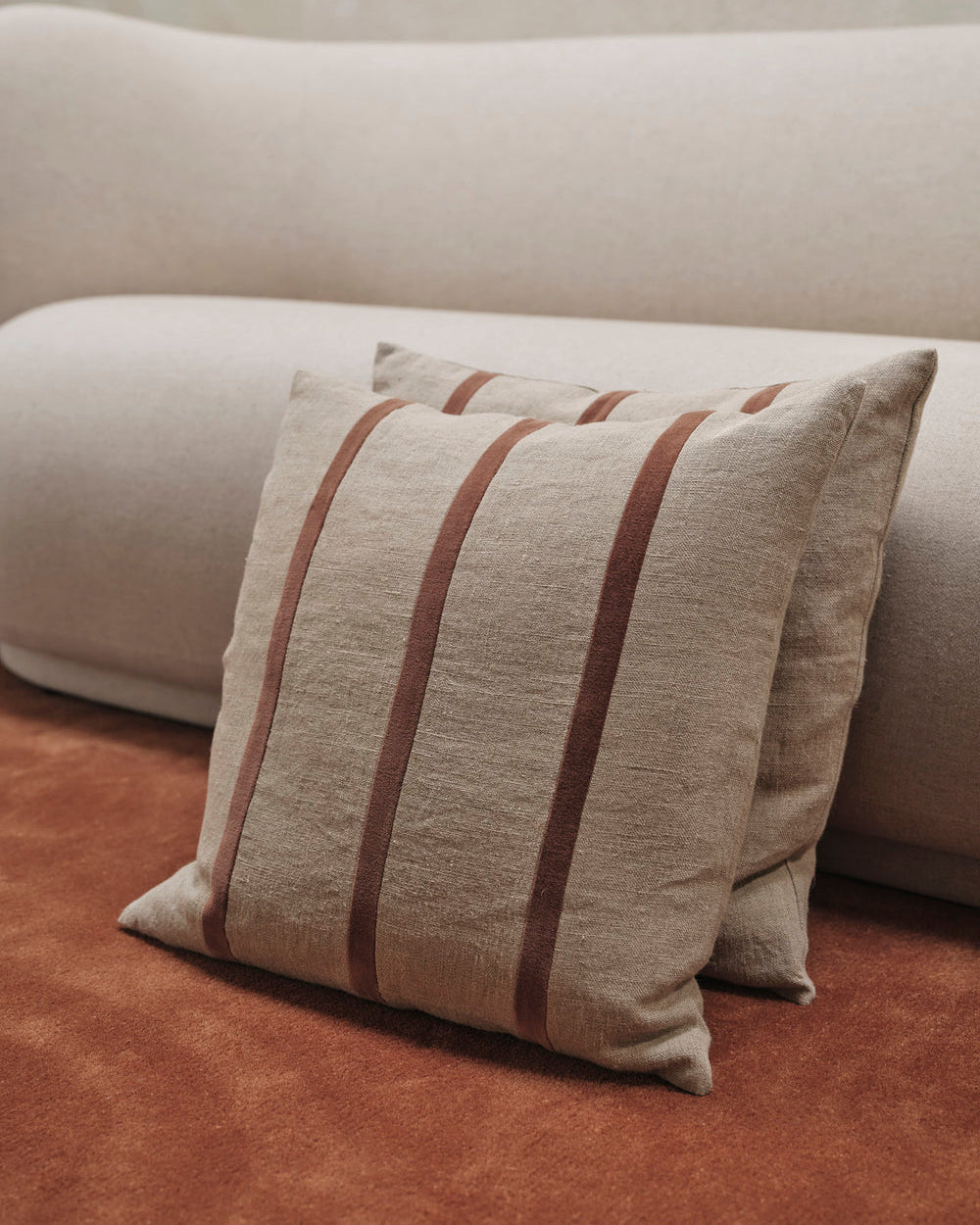 Beige cushion with brown stripes on a beige sofa
